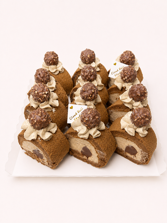 12 chocolate cake rolls decorated with piped cream and topped with chocolate-covered spheres, arranged on a white plate against a clean white background.